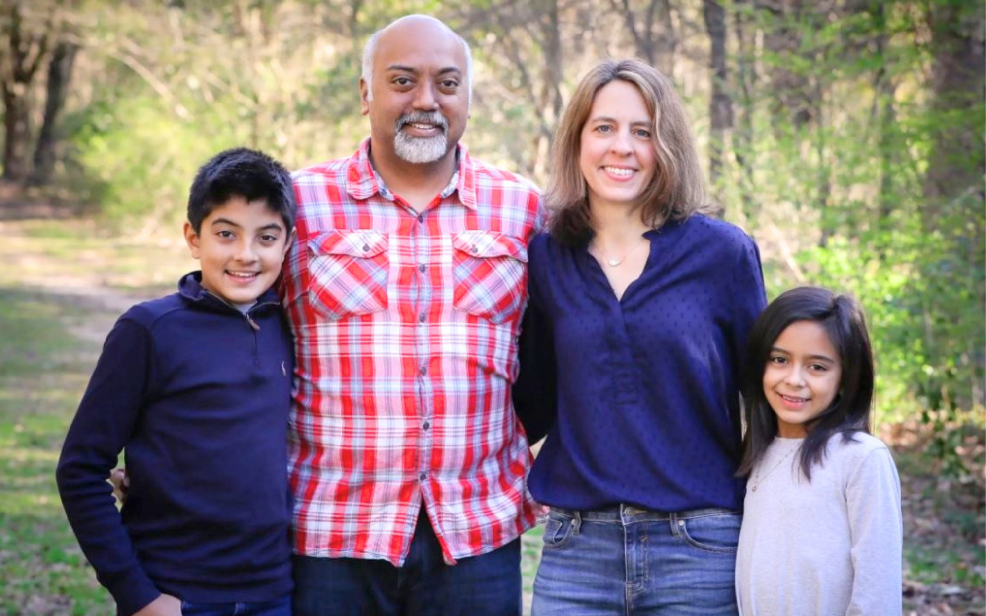 Sanjay Premakumar and Jodi Lynn Koviach smiling outdoors with their two children